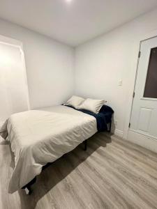 Cette chambre blanche dispose d'un lit. dans l'établissement Appartement 1 chambre - 101, à Montréal