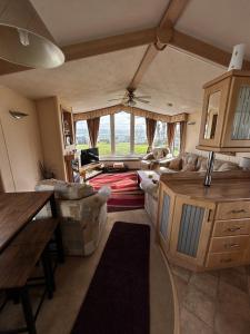 a living room with a couch and a table at Bay 1 in Kirkcolm