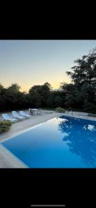 a large blue swimming pool with lounge chairs and trees at Pool Rooftop Kadikoy Bagdat St. Seaside metro 5mins Metro in Istanbul