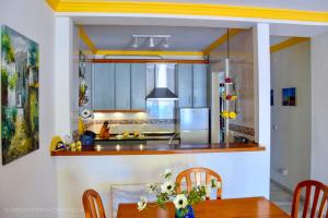 a kitchen with a table and chairs and a stove at Komfortable Ferienwohnung erste Strandreihe Playa Burriana in Nerja