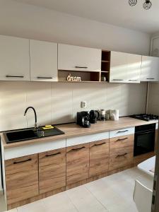 een keuken met houten kasten en een wastafel bij Greenlight Studio by DAT Apartments in Cluj-Napoca