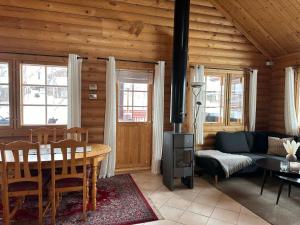 sala de estar con mesa y fogones en Koslig tømmerhytte, en Kilpisjärvi