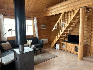 una sala de estar con una escalera en una cabaña de madera en Koslig tømmerhytte en Kilpisjärvi