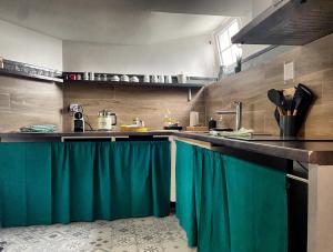 een keuken met groene gordijnen aan de toonbank bij NATICOSY-Appartement centre historique avec jardin IDEAL COUPLE in Bellême