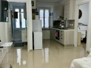 a kitchen with a white refrigerator and a stove at Azadi Center Apartment in Rome