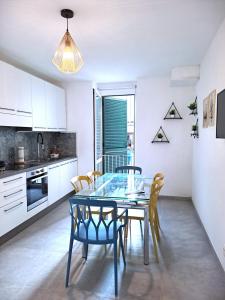 cocina y comedor con mesa de cristal y sillas en Casa del Cigno, en Monterotondo