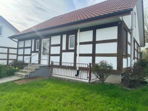 ein Schwarz-Weiß-Haus mit einer Veranda in der Unterkunft Alcor Hotel Feriendorf an der Ostsee in Wohlenberg