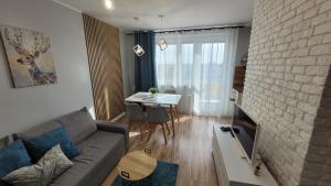 uma sala de estar com um sofá e uma mesa em Dwupokojowy apartament Fordon w okolicy Onkologii em Bydgoszcz