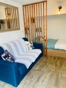 uma sala de estar com um sofá azul e uma cama em Appart'Hotel au Pradet em Le Pradet