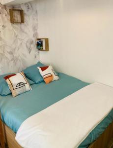 a bed with two pillows on top of it at Appart'Hotel au Pradet in Le Pradet