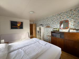 um quarto com uma cama branca e um espelho em Fagrabrekka Private Room em Stadur