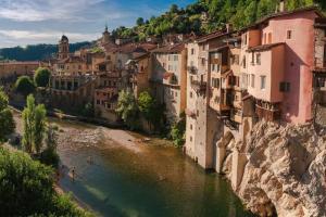 a group of buildings on the side of a river at Maison suspendue avec jacuzzi privatif in Pont-en-Royans