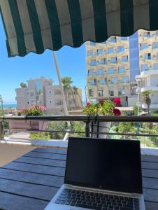 een laptop op een tafel voor een balkon bij Florida Apartment Golem in Golem