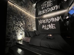 a room with a bed with writing on the wall at DoorMat#13 Black Mirror in Thessaloniki