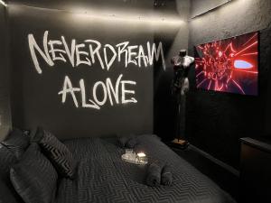 a bedroom with a bed with a wall with writing on it at DoorMat#13 Black Mirror in Thessaloniki