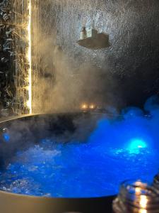 a bath tub filled with blue water in a room at DoorMat#13 Black Mirror in Thessaloniki