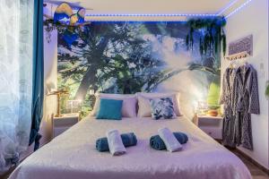 a bedroom with a bed with pillows on it at Jungle Spa - Cocon romantique et tropical avec jacuzzi privé ! in Pézenas