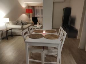 una mesa blanca y sillas en la sala de estar. en Apartamento centrico familiar en Valencia( Frente Estacion Ave ,Joaquin Sorolla), en Valencia