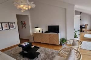 a living room with a couch and a tv at Boutique Rooftop with Ocean views in São Martinho do Porto