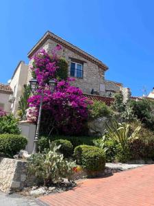 a house with purple flowers and a street light at MORINGA - New unit for 2 AC close to beach in Antibes