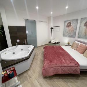 a bedroom with a large bed and a bath tub at Namuri Luxury Rooms in Taormina