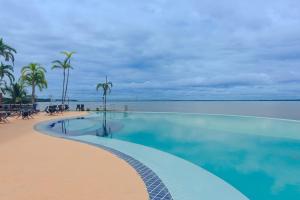 uma piscina junto ao oceano com palmeiras em Tropical Executive N 905 em Manaus