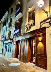 un edificio con porte in legno sul lato di una strada di Santa Rita Rita B&Boutique a Talavera de la Reina