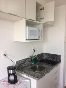 cocina con fregadero y microondas en Aconchegante estúdio para sua estadia!, en São Paulo