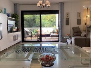 uma sala de estar com uma mesa de vidro e um sofá em Duquesa del Mar Apartmento em Manilva