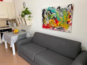 un soggiorno con divano e un dipinto sul muro di Le Palme House Isola delle Femmine a Isola delle Femmine