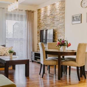 uma sala de estar com uma mesa de jantar e cadeiras em Apartament 7 em Szklarska Poręba