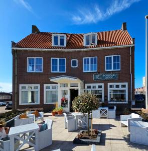 a red brick building with white furniture in front of it at Boutique Lodge Zandvoort in Zandvoort