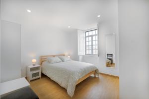 - une chambre blanche avec un lit et une fenêtre dans l'établissement Casa de Cardigos, à Cardigos