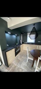 a kitchen with a stove and a table and a chair at Appartement T2 au calme in Toulon