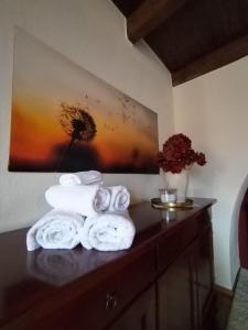 einen Haufen Handtücher auf einer Theke in einem Zimmer in der Unterkunft Little Country House in Bellano