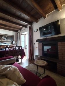 een woonkamer met een open haard en een tv aan de muur bij Little Country House in Bellano