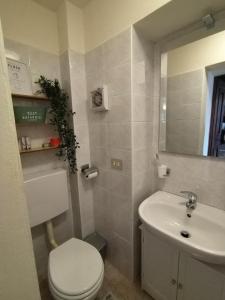 Łazienka z białą toaletą i umywalką w obiekcie Little Country House w mieście Bellano