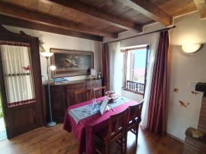 a dining room with a table with a purple table cloth at Little Country House in Bellano