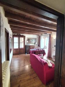 een woonkamer met een rode bank en een tafel bij Little Country House in Bellano