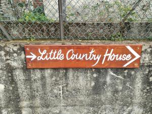 ein Schild für ein kleines Landhaus an der Wand in der Unterkunft Little Country House in Bellano