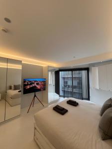 a bedroom with a large bed with a flat screen tv at Casa Olmi in Shoreditch in London