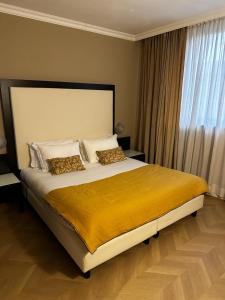 um quarto com uma cama grande e um cobertor amarelo em Hotel Comtur em Binasco