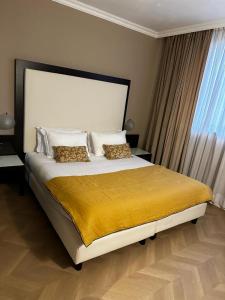 a bedroom with a large bed with a yellow blanket at Hotel Comtur in Binasco