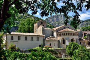 an old building with a mountain in the background at Jungle Spa - Cocon romantique et tropical avec jacuzzi privé ! in Pézenas