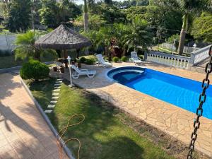 a backyard with a swimming pool and a gazebo at Atibaia - Casa de Campo in Atibaia