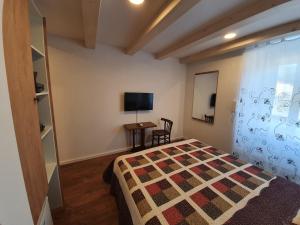 a bedroom with a bed and a table and a tv at Room CS Cres in Cres