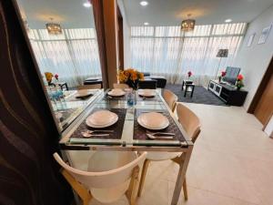 a dining room with a glass table and chairs at VORTEX KLCC Apartment Kuala Lumpur Bukit Bintang in Kuala Lumpur
