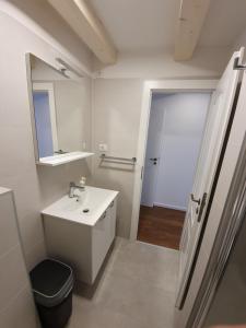 a white bathroom with a sink and a mirror at Room CS Cres in Cres