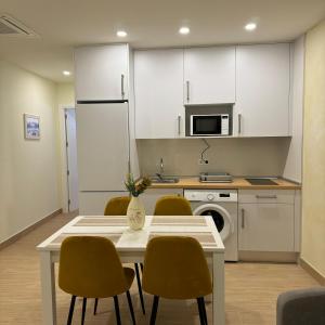 a kitchen with a table and chairs and a microwave at Apartamentos Jardines in Ciempozuelos