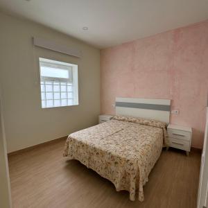 een slaapkamer met een bed en een raam bij Apartamentos Jardines in Ciempozuelos